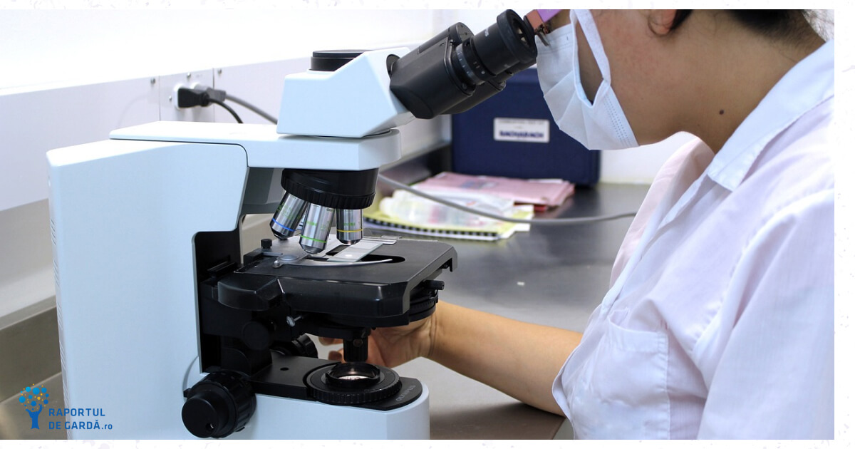 un cercetator analizează o lamă la microscopul optic